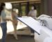 doctor-sosteniendo-el-bloc-de-notas-en-el-centro-de-vacunacion-con-pacientes-al-aire-libre